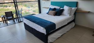 uma cama grande num quarto com uma janela grande em Santa Marta- Pozos Colorados Ocean view Suite Bello Horizonte em Santa Marta