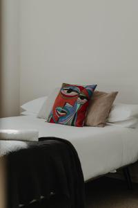 a white bed with a pillow on top of it at Cosy 1-Bed In Peaceful Location Across From Park in Canberra
