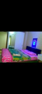 1 dormitorio con 2 camas y mesa con lámpara en DR.ROOM APARTEMEN, en Pondokcabe Hilir