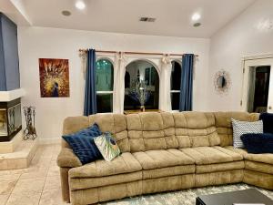a living room with a brown couch and blue curtains at Peacock House Sleeps 12 Hot Tub Game Room in Ahwahnee +35 photos