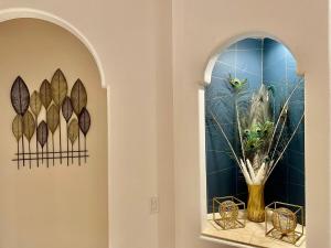 a hallway with two windows with a vase with feathers at Peacock House Sleeps 12 Hot Tub Game Room in Ahwahnee