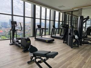 un gimnasio con varias máquinas de correr en una habitación con ventanas en PAVILION EMBASSY KLCC By ELITE HOST en Kuala Lumpur