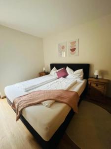 een slaapkamer met 2 bedden met witte lakens en rode kussens bij Martina 4 by SMR Rauris Apartments - inc Spa and National Summercard - near Gondola in Rauris