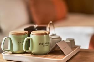 two coffee mugs sitting on a tray on a table at Panda Hotel in Chengdu