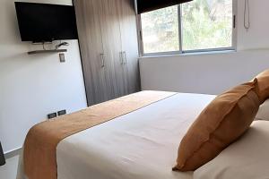 a bedroom with a bed with a pillow on it at 303 Moderno Aparta-Suite en Versalles Tipo Loft - Cali Tower Suites & Lofts in Cali