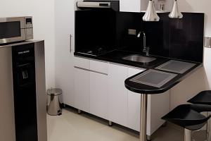 a black and white kitchen with a sink and a microwave at 303 Moderno Aparta-Suite en Versalles Tipo Loft - Cali Tower Suites & Lofts in Cali