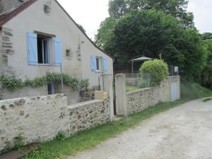 a white house with a stone wall next to a road at Gîte de charme avec jardin privatif près de la Loire - FR-1-381-95 in Montlouis-sur-Loire
