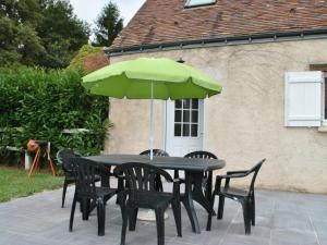 een zwarte tafel en stoelen met een groene paraplu bij Gîte Luynes, 4 pièces, 6 personnes - FR-1-381-393 in Luynes