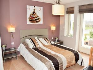 Un dormitorio con una cama grande y dos ventanas. en Séjour détente en Touraine : maison de charme avec spa, sauna, fitness, jardin clos et équipements pour bébé - FR-1-381-473, en Benais