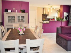 Un comedor y una cocina con una mesa y paredes moradas. en Séjour détente en Touraine : maison de charme avec spa, sauna, fitness, jardin clos et équipements pour bébé - FR-1-381-473, en Benais 26 fotos más