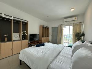 a bedroom with a white bed and a television at STAYDII serviced residence Chaengwattana in Pak Kret