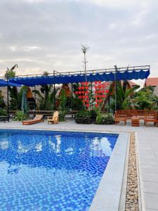 a pool at the resort with benches and a canopy at Tamcoc Metoo Bungalow 2 in Ninh Binh