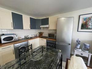 a kitchen with a refrigerator and a table in it at Appartement confortable au centre de Banyuls, à 300 m de la plage, idéal pour 4 personnes - FR-1-309-5 in Banyuls-sur-Mer