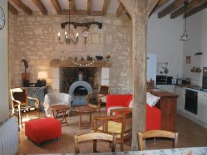 a living room with a table and chairs and a fireplace at Gîte Saint-Senoch, 4 pièces, 7 personnes - FR-1-381-40 in Saint-Senoch