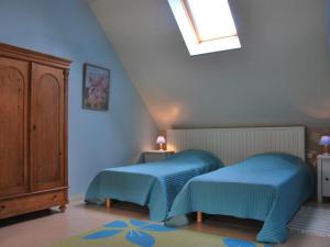 Gîte Saint-Senoch, 4 pièces, 7 personnes - FR-1-381-40 في Saint-Senoch: سريرين في غرفة نوم بجدران زرقاء