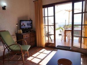 een woonkamer met een televisie en een glazen schuifdeur bij Casa L'Estartit, 2 dormitorios, 5 personas - ES-323-57 in L'Estartit
