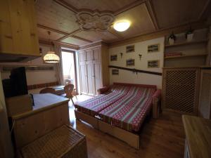 a bedroom with a bed and a table in a room at Appartamento Brentegani in Arabba