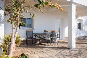 Un patio con una mesa y sillas y un árbol. en Apartments with a parking space Poljica, Zadar - 21807, en Vrsi