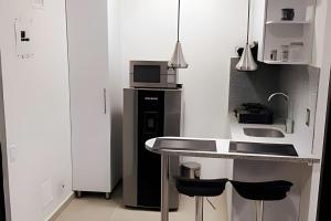 uma cozinha com um lavatório e um micro-ondas em 304 Moderno Aparta-Suite en Versalles Tipo Loft - Cali Tower Suites & Lofts em Cali