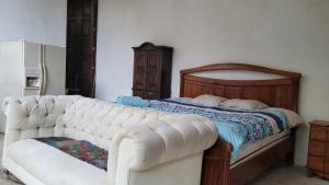 a bedroom with a white couch next to a bed at Cabaña privada in San Lucas Sacatepéquez