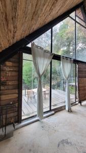 two white curtains are hanging in a room with windows at Cabaña privada in San Lucas Sacatepéquez