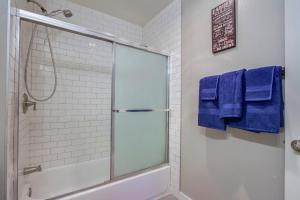 a bathroom with a shower with blue towels at Entire Spacious 4-Bedroom House w Free Pool Access, Garage & Parking in Prime Location in San Diego