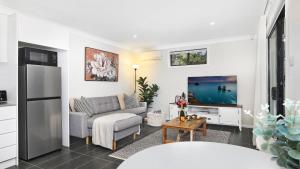 a living room with a couch and a tv at Ravello in Callala Bay