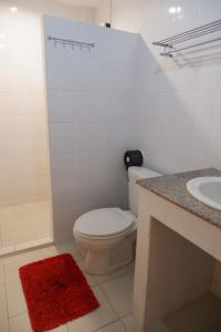 a white bathroom with a toilet and a sink at Goldbeach guesthouse in Ko Chang