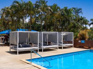 a swimming pool with two lounge chairs next to a swimming pool at NRMA Capricorn Yeppoon Holiday Park in Yeppoon