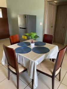 a dining room table with blue plates and a plant on it at Acogedora casa en Alto Boquete, Las Trancas 1 in Boquete