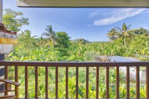 a balcony with a view of the jungle at Ped Cottage in Nusa Penida