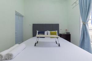a bedroom with a large white bed with two pillows at Urbanview Hotel Nakasya Burangrang in Bandung