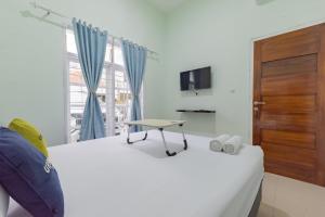 um quarto com uma cama com uma mesa em Urbanview Hotel Nakasya Burangrang em Bandung