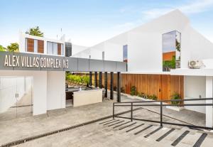 ein großes weißes Haus mit einem Schild mit der Aufschrift „Alza Villas Cornerel US“ in der Unterkunft Alex Villas Complex N3 in Canggu