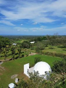 a white dome tent in a field with trees at Glamping Venecia in Alajuela