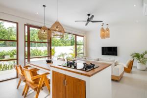 eine Küche und ein Wohnzimmer mit Tisch und Stühlen in der Unterkunft Casa Maro Uluwatu in Uluwatu