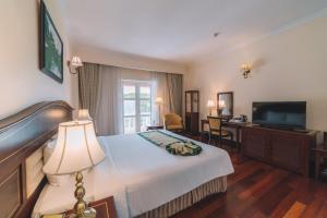 una camera d'albergo con un letto e una TV a schermo piatto di Saigon Dalat Hotel a Da Lat