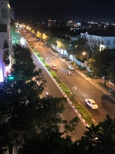 une rue de la ville la nuit avec des voitures sur la route dans l'établissement Hotel Bình An, à Vung Tau