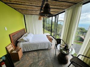 una camera con un letto e una grande finestra di Glamping ríos voladores pereira a Pereira