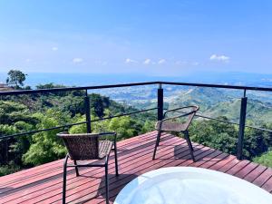 a balcony with a tub and two chairs on a deck at Glamping ríos voladores pereira in Pereira