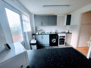 a small kitchen with a stove and a dishwasher at Stay Sleep Rest Heeley, Sheffield in Heeley