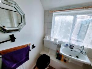 een kleine badkamer met een wastafel en een raam bij Stay Sleep Rest Heeley, Sheffield in Heeley