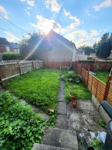 a backyard with a fence and a yard with plants at Stay Sleep Rest Heeley, Sheffield in Heeley