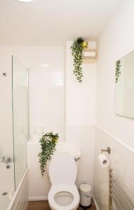 エンフィールドにあるThe Green Lodge (Bush Hill Park)のバスルーム(壁に植物2本が並ぶトイレ付)