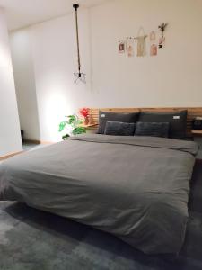 um quarto com uma cama grande e lençóis cinzentos em Ngày Tháng 5 - MayDay em Da Lat