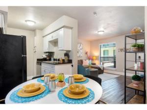a kitchen and living room with a table with plates on it at The Flamingo 102 l Pool I 65 Smart TV I Sleeps 5 in Austin