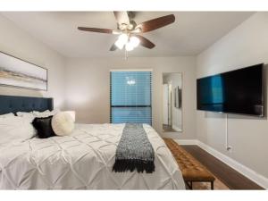 a bedroom with a bed and a ceiling fan at The Flamingo 102 l Pool I 65 Smart TV I Sleeps 5 in Austin