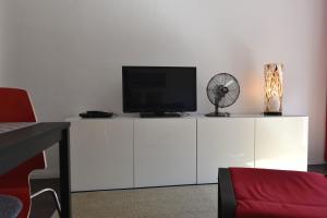 a white entertainment center with a television on top of it at HertenFlats - Rooms & Apartments - Kreis Recklinghausen in Herten