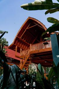 a tree house with a wooden deck on top at Kusfarm Bali in Selemadeg