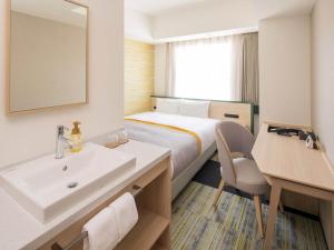 een hotelkamer met een bed en een wastafel bij La'gent Stay Shin Sapporo in Sapporo